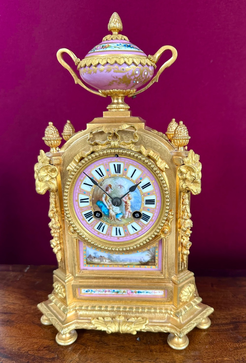 A late 19th-century French gilt bronze mantel clock featuring pink hand-painted porcelain panels and an urn finial. View VI