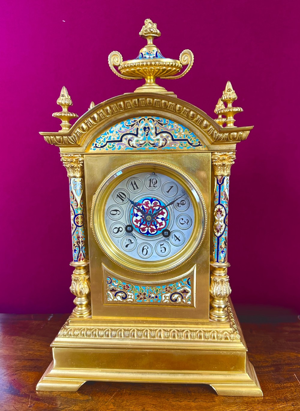 A late 19th-century French gilt-bronze mantel clock decorated with multicoloured champleve enamel scrollwork, columns, and an urn finial. View III