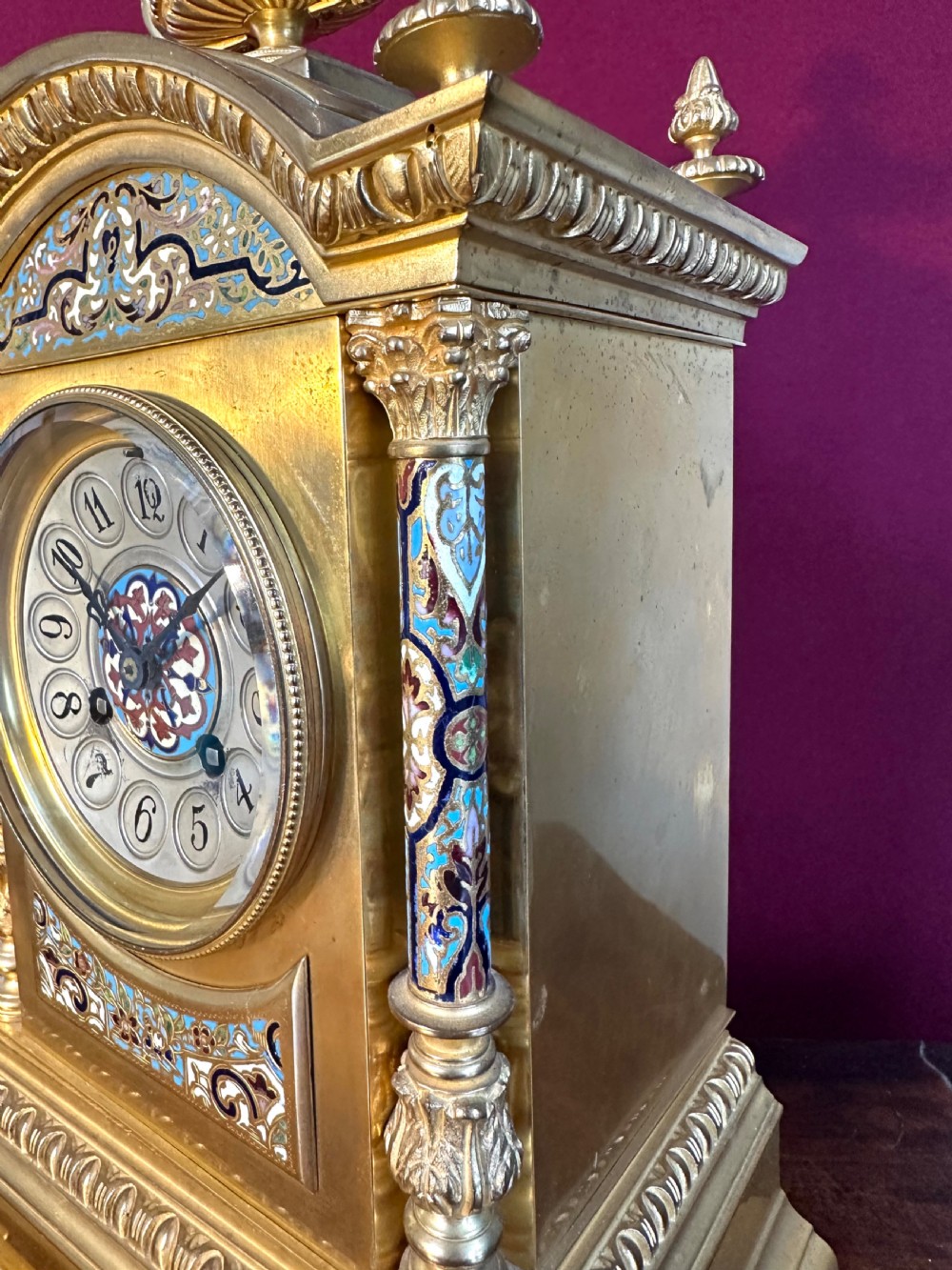 A late 19th-century French gilt-bronze mantel clock decorated with multicoloured champleve enamel scrollwork, columns, and an urn finial. View IV