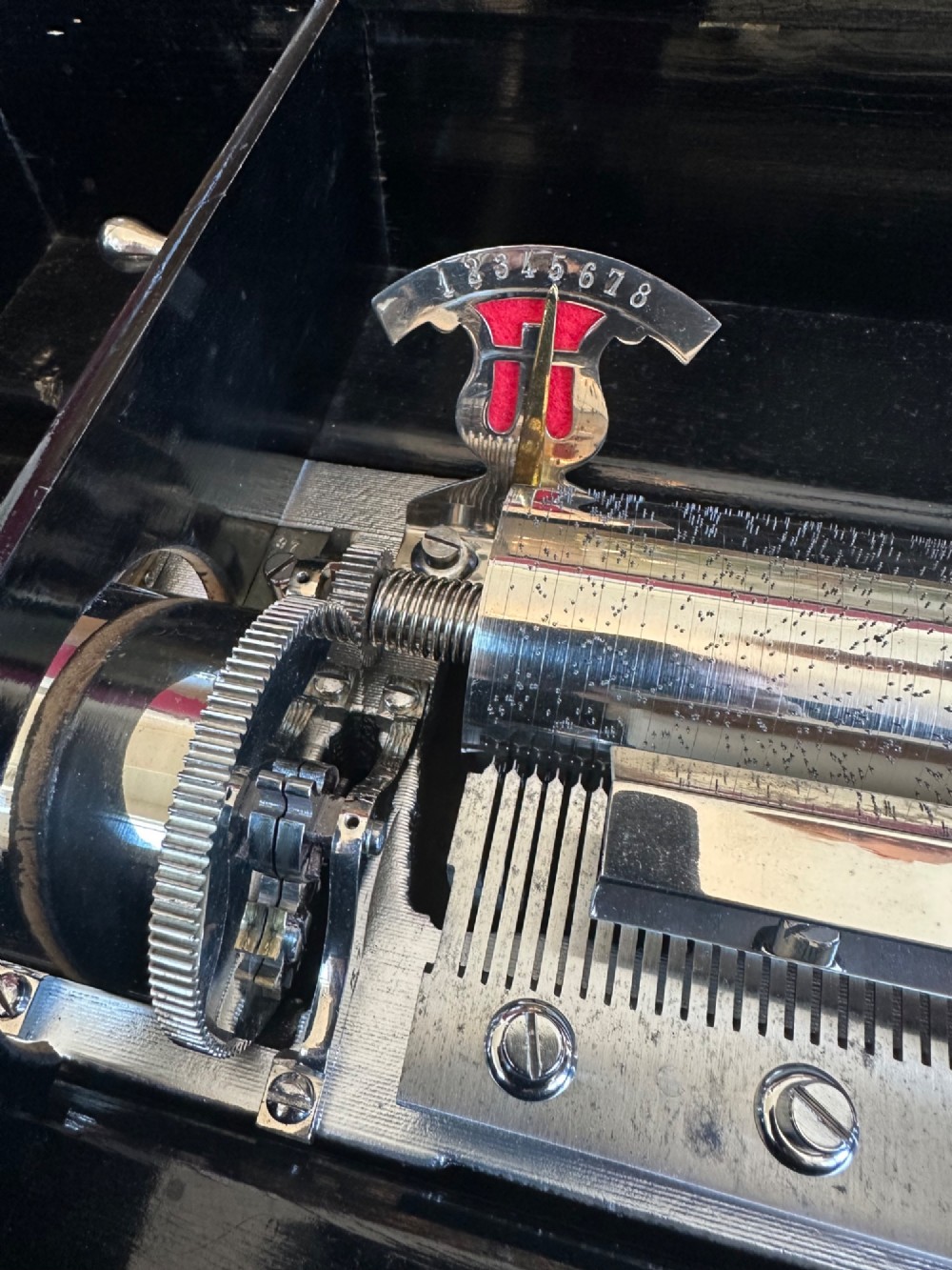 A late nineteenth-century Victorian walnut cylinder music box with an open hinged lid displaying an illustrated tune sheet and an internal brass mechanism behind a glass cover. View III