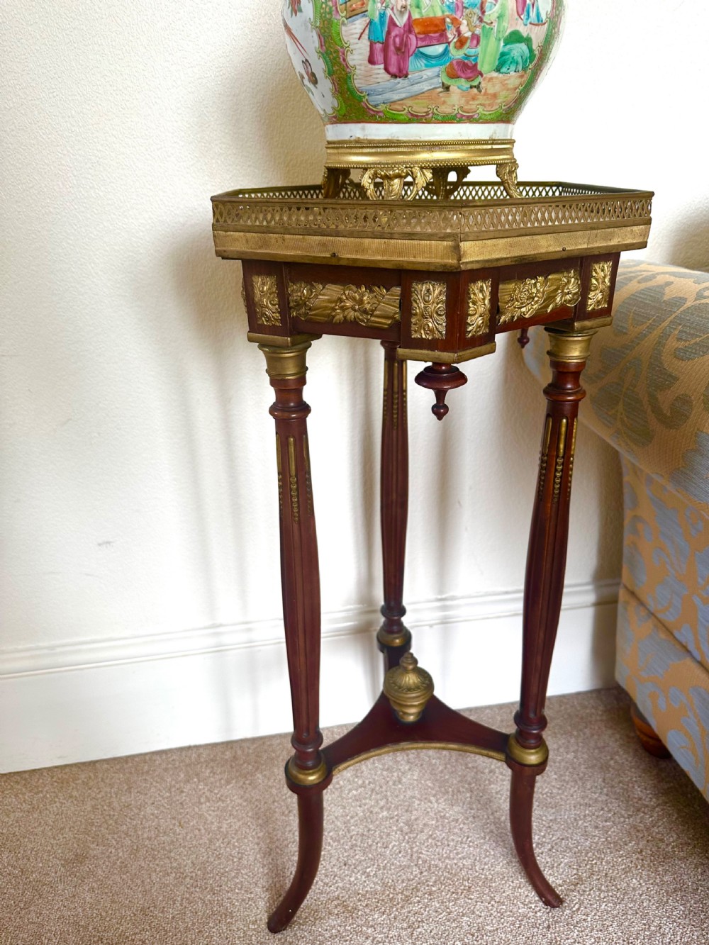 A late nineteenth-century Victorian plant stand featuring turned fluted legs, brass mounts, a pierced gallery, and a marble inset top. View VI