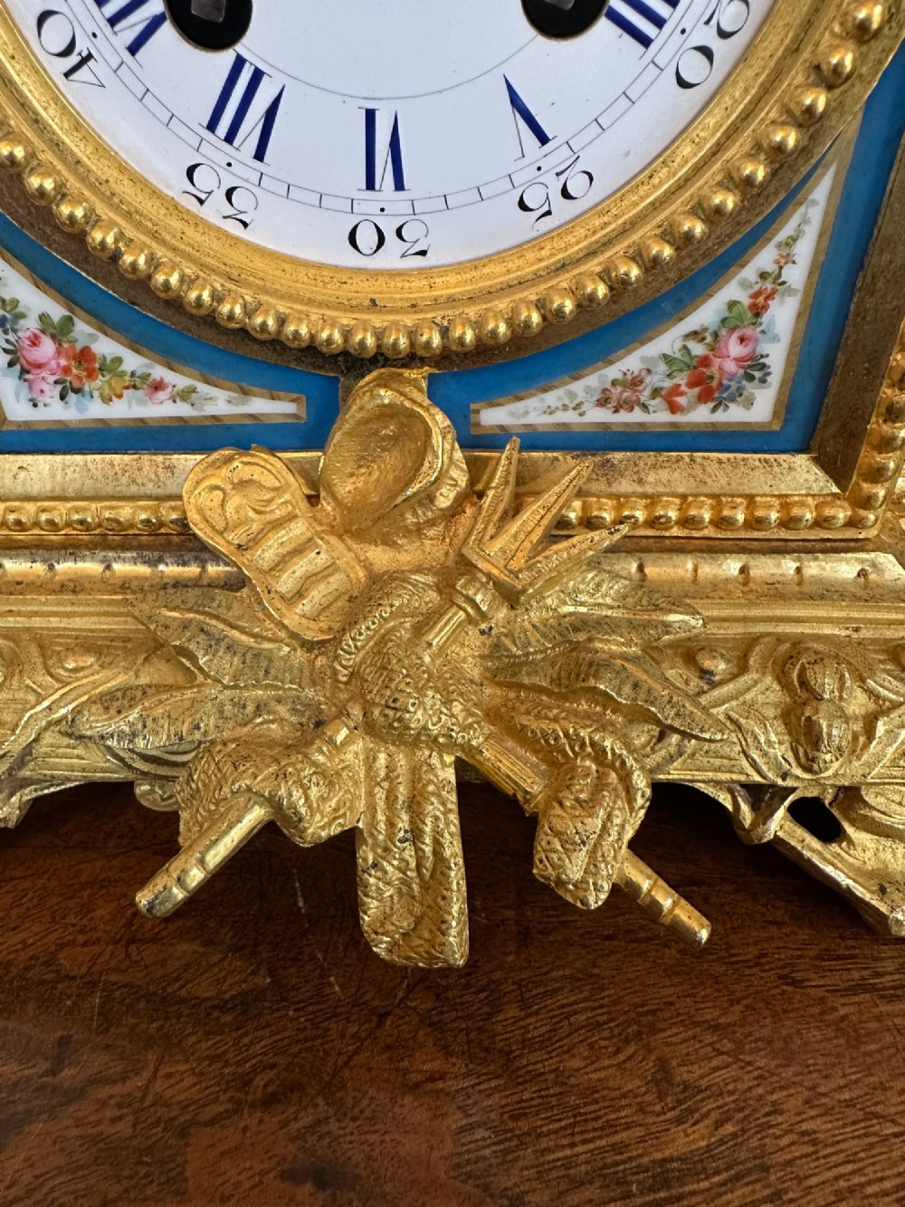A late 19th-century French gilt bronze mantel clock crowned with a seated cherub figure and featuring an enamel dial with blue porcelain panels. View III