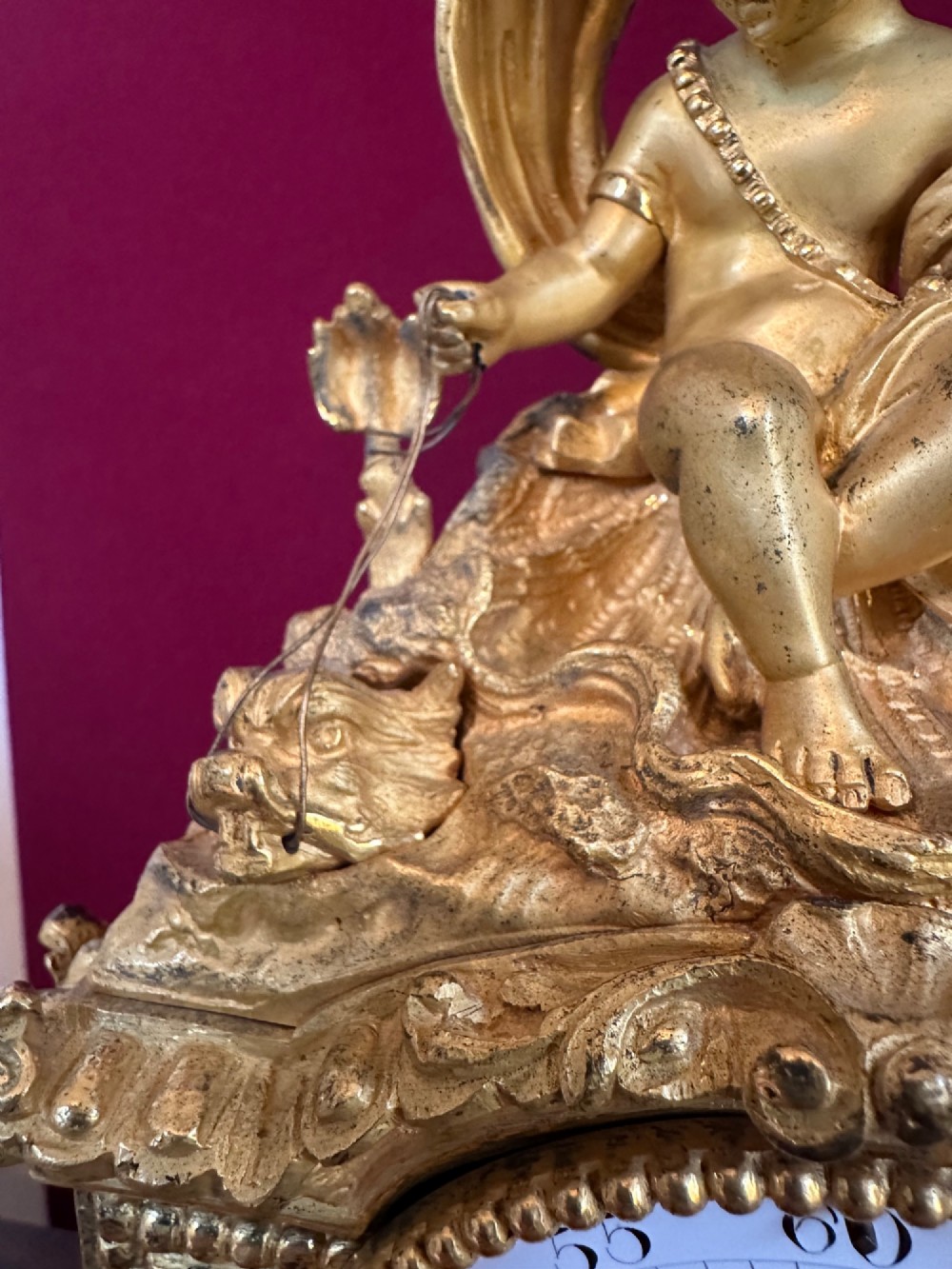 A late 19th-century French gilt bronze mantel clock crowned with a seated cherub figure and featuring an enamel dial with blue porcelain panels. View VIII