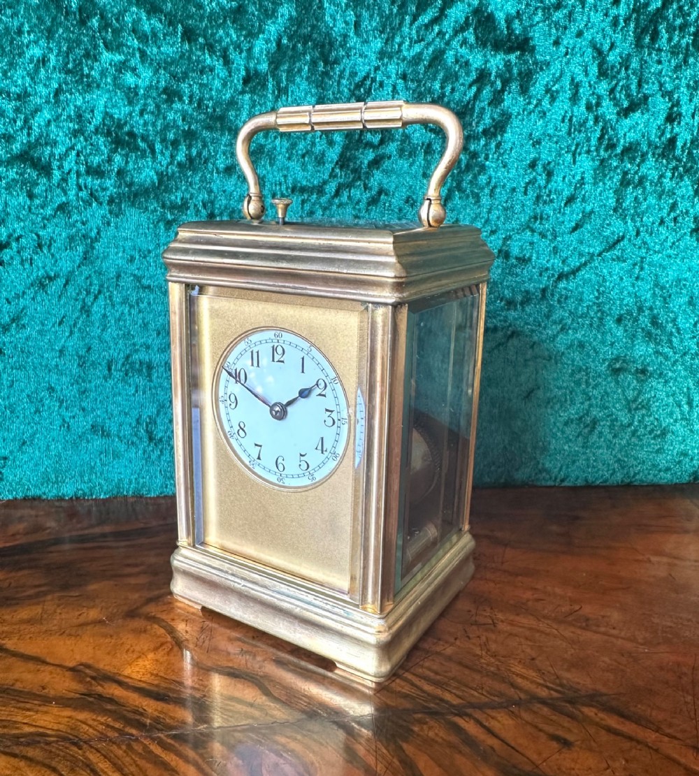 A 19th-century brass repeating carriage clock featuring bevelled glass panels, a top carrying handle, and an enamel dial with Arabic numerals.