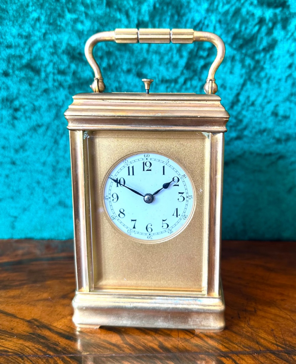 A 19th-century brass repeating carriage clock featuring bevelled glass panels, a top carrying handle, and an enamel dial with Arabic numerals. View II