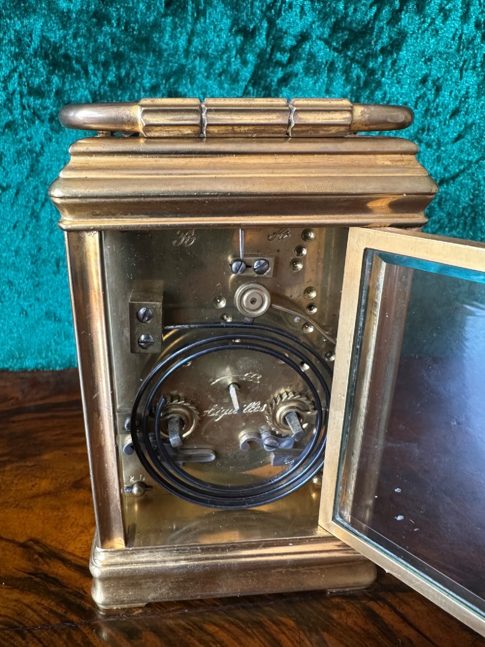 A 19th-century brass repeating carriage clock featuring bevelled glass panels, a top carrying handle, and an enamel dial with Arabic numerals. View V