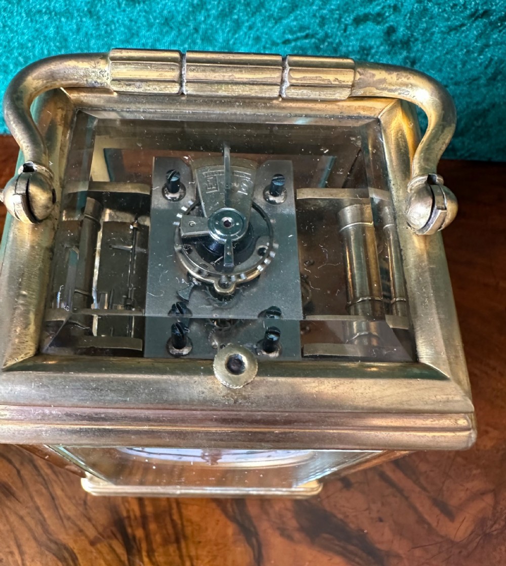A 19th-century brass repeating carriage clock featuring bevelled glass panels, a top carrying handle, and an enamel dial with Arabic numerals. View VI