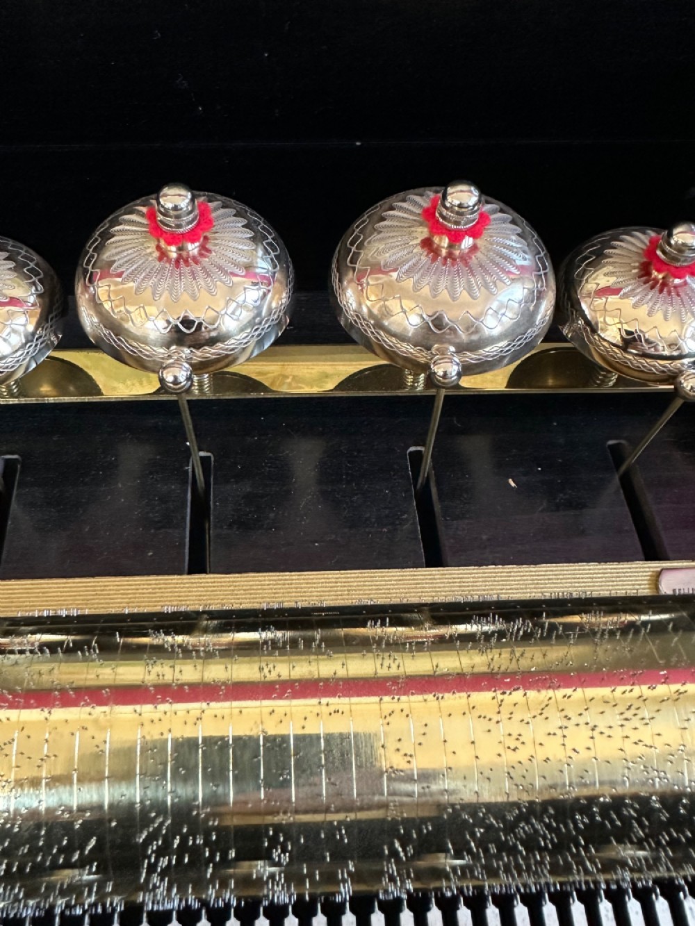 An open Victorian cylinder music box housed in a dark veneered wooden case featuring six exposed bells and an illustrated tune sheet inside the lid. View IV