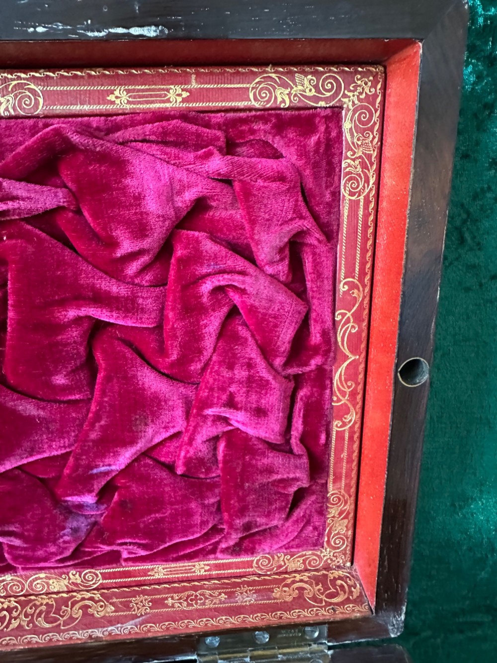 An open Victorian wooden travelling dressing case featuring vibrant red velvet lining, glass toiletry jars, engraved silver lids, and small compartments. View II