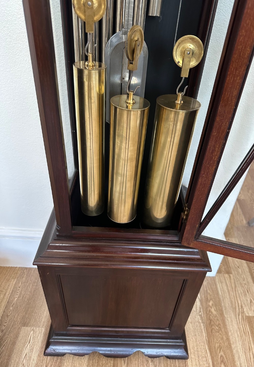 An Edwardian mahogany longcase clock featuring an arched pediment, a brass dial with chime selectors, and a glazed door revealing polished brass weights and tubular bells. View III