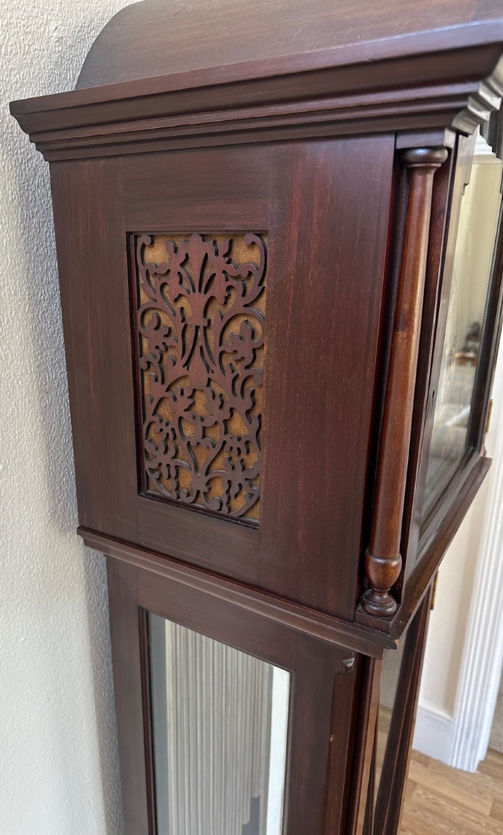 An Edwardian mahogany longcase clock featuring an arched pediment, a brass dial with chime selectors, and a glazed door revealing polished brass weights and tubular bells. View IV