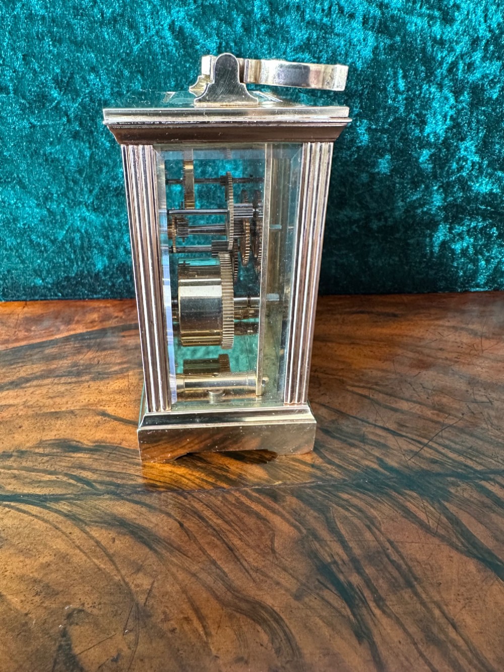 A rectangular brass carriage clock featuring bevelled glass side panels, a top handle, and a white enamel dial with Roman numerals marked Mappin & Webb London. View II