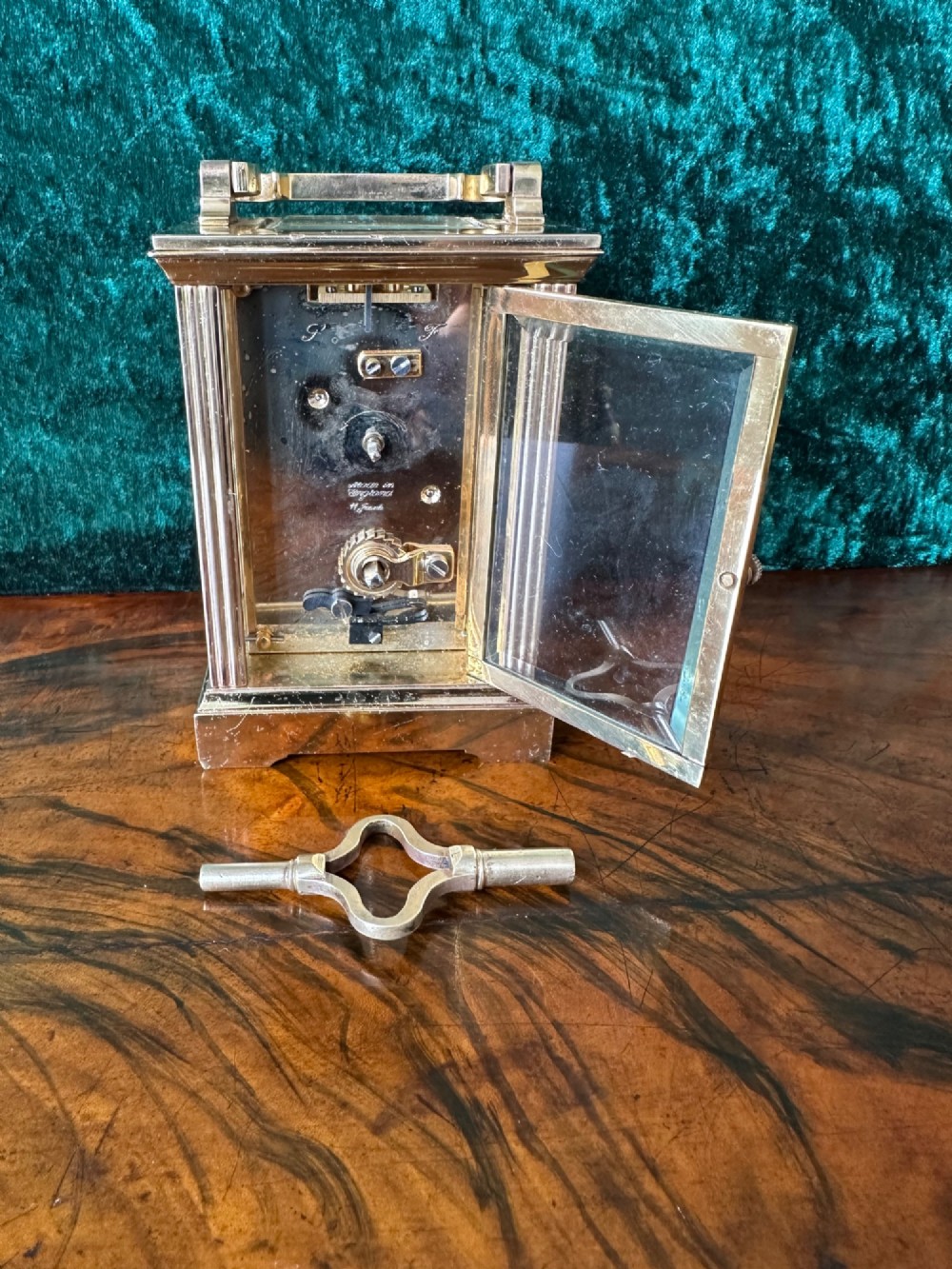 A rectangular brass carriage clock featuring bevelled glass side panels, a top handle, and a white enamel dial with Roman numerals marked Mappin & Webb London. View III