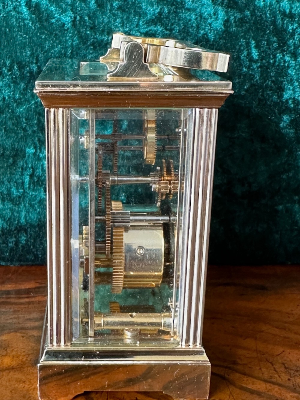 A rectangular brass carriage clock featuring bevelled glass side panels, a top handle, and a white enamel dial with Roman numerals marked Mappin & Webb London. View IV