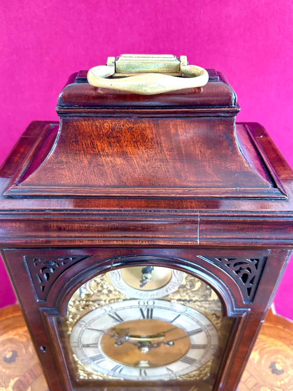 A mid-18th-century Georgian mahogany bracket clock featuring an upper brass carrying handle, an arched glass front door, and an engraved brass dial with a silvered chapter ring. View III