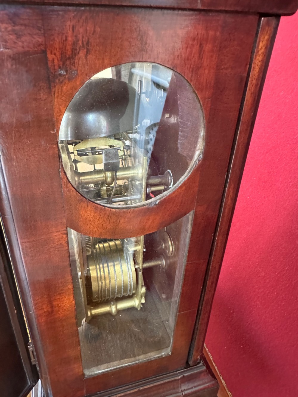 A mid-18th-century Georgian mahogany bracket clock featuring an upper brass carrying handle, an arched glass front door, and an engraved brass dial with a silvered chapter ring. View VIII