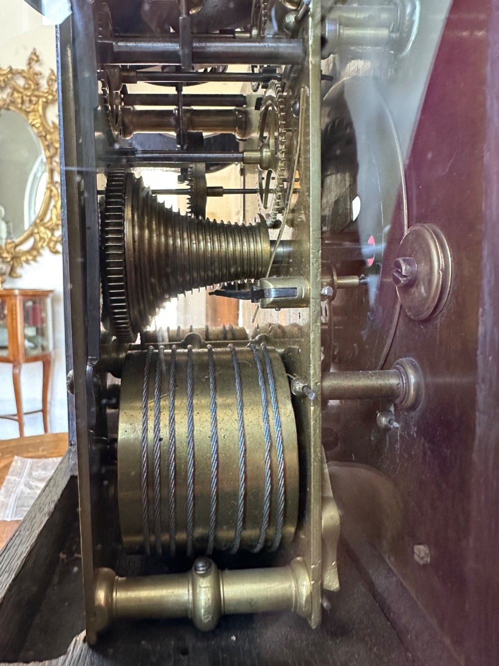 A mid-18th-century Georgian mahogany bracket clock featuring an upper brass carrying handle, an arched glass front door, and an engraved brass dial with a silvered chapter ring. View IX