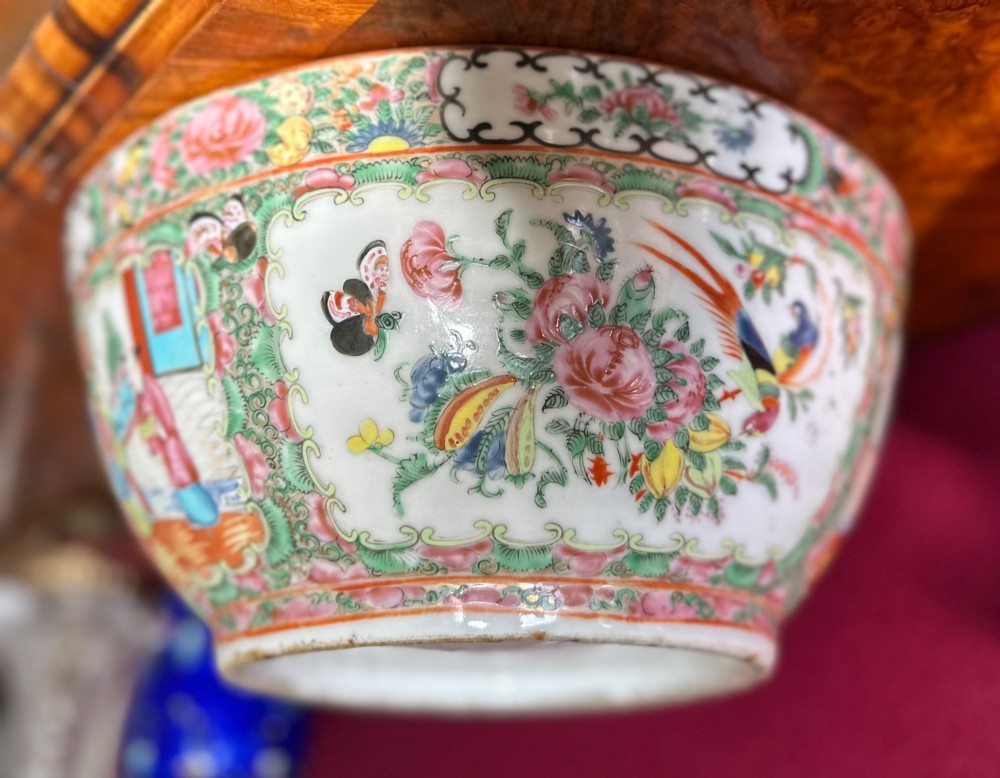 A circular Chinese export porcelain bowl featuring hand-painted panels with human figures in courtly attire framed by floral borders. View II