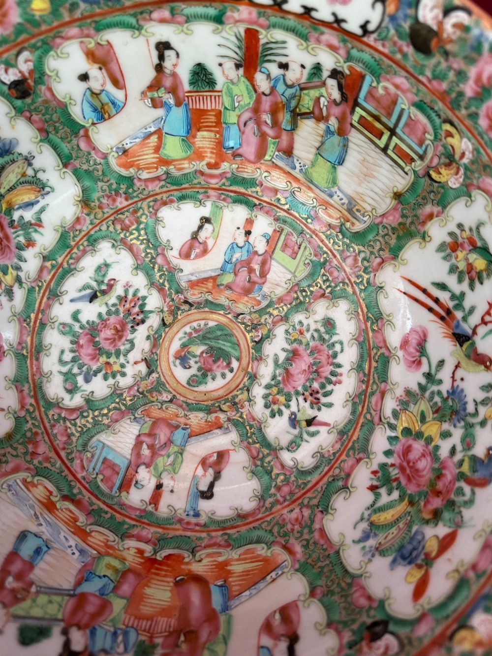 A circular Chinese export porcelain bowl featuring hand-painted panels with human figures in courtly attire framed by floral borders. View VI