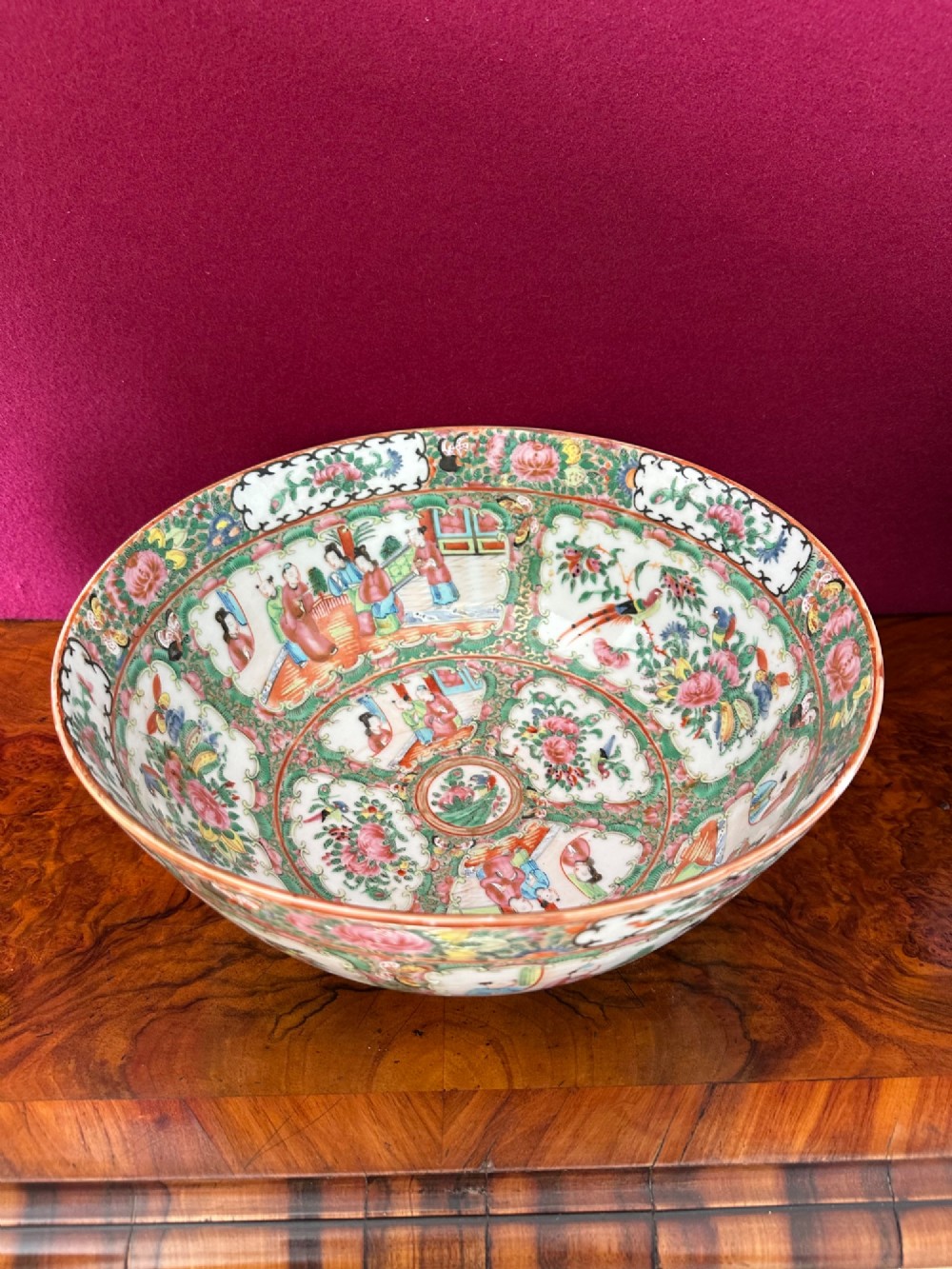 A circular Chinese export porcelain bowl featuring hand-painted panels with human figures in courtly attire framed by floral borders. View VII