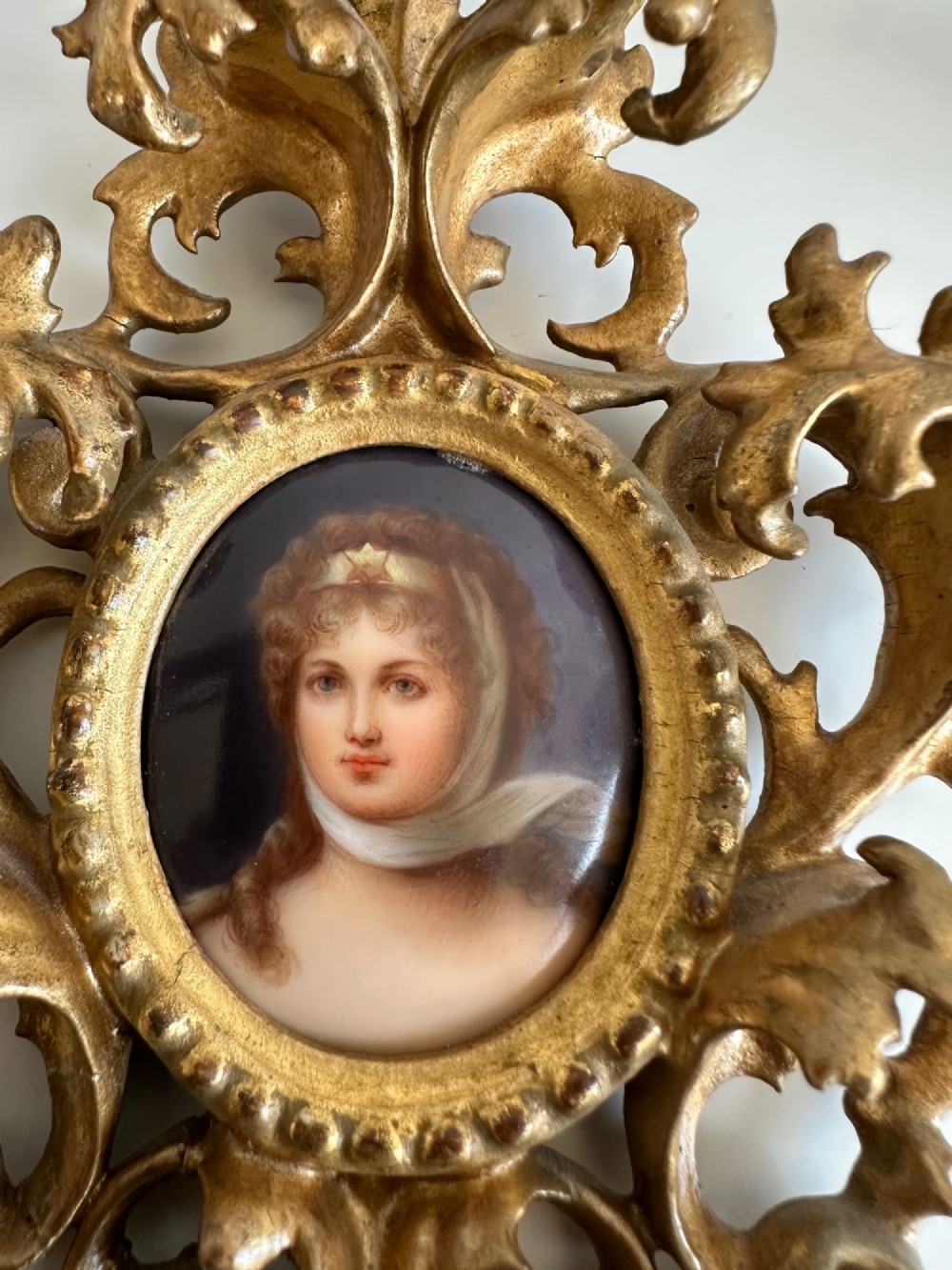 A late 19th-century oval miniature portrait of a woman set within an elaborate gilt metal frame featuring acanthus scrollwork and pierced details. View III