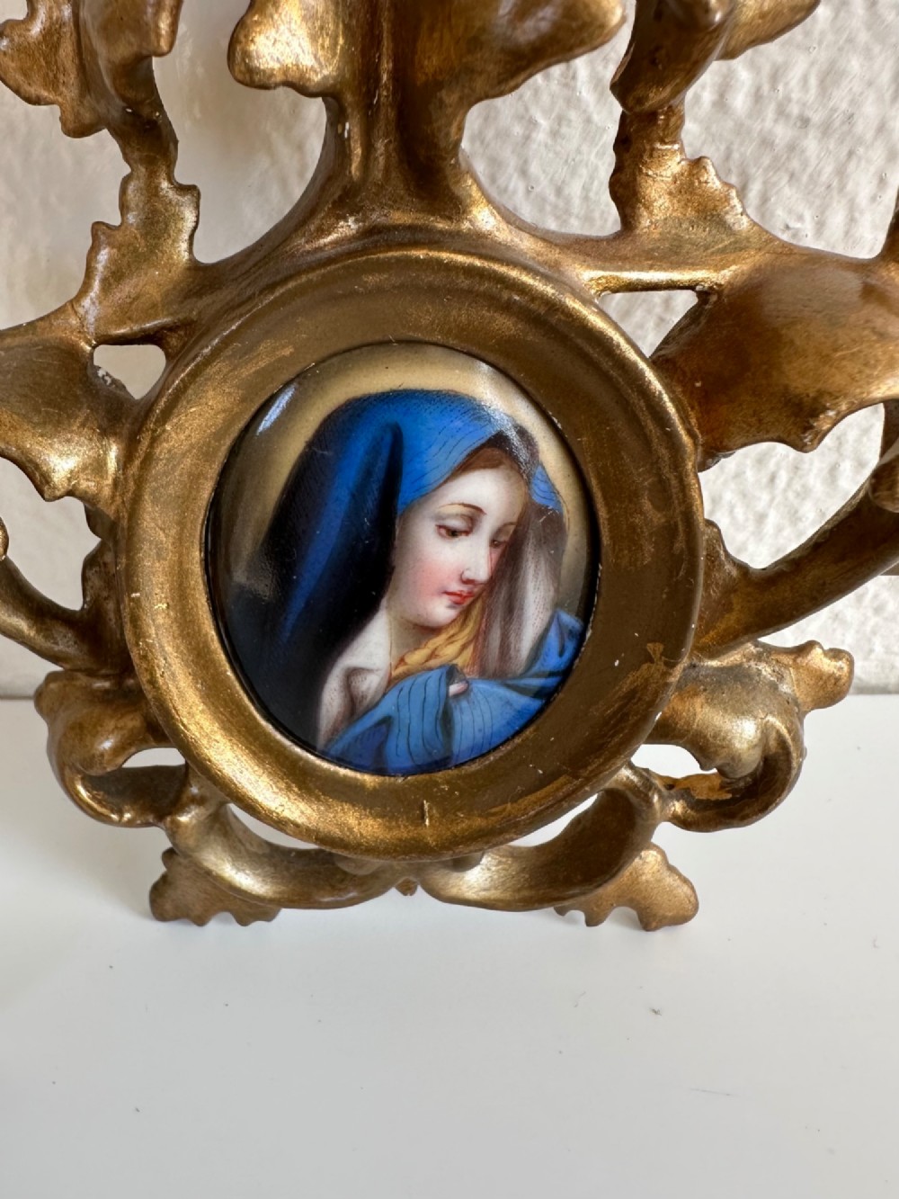 A small Victorian oval miniature portrait of the Madonna in a blue veil, set within a gilt metal scrollwork frame. View III