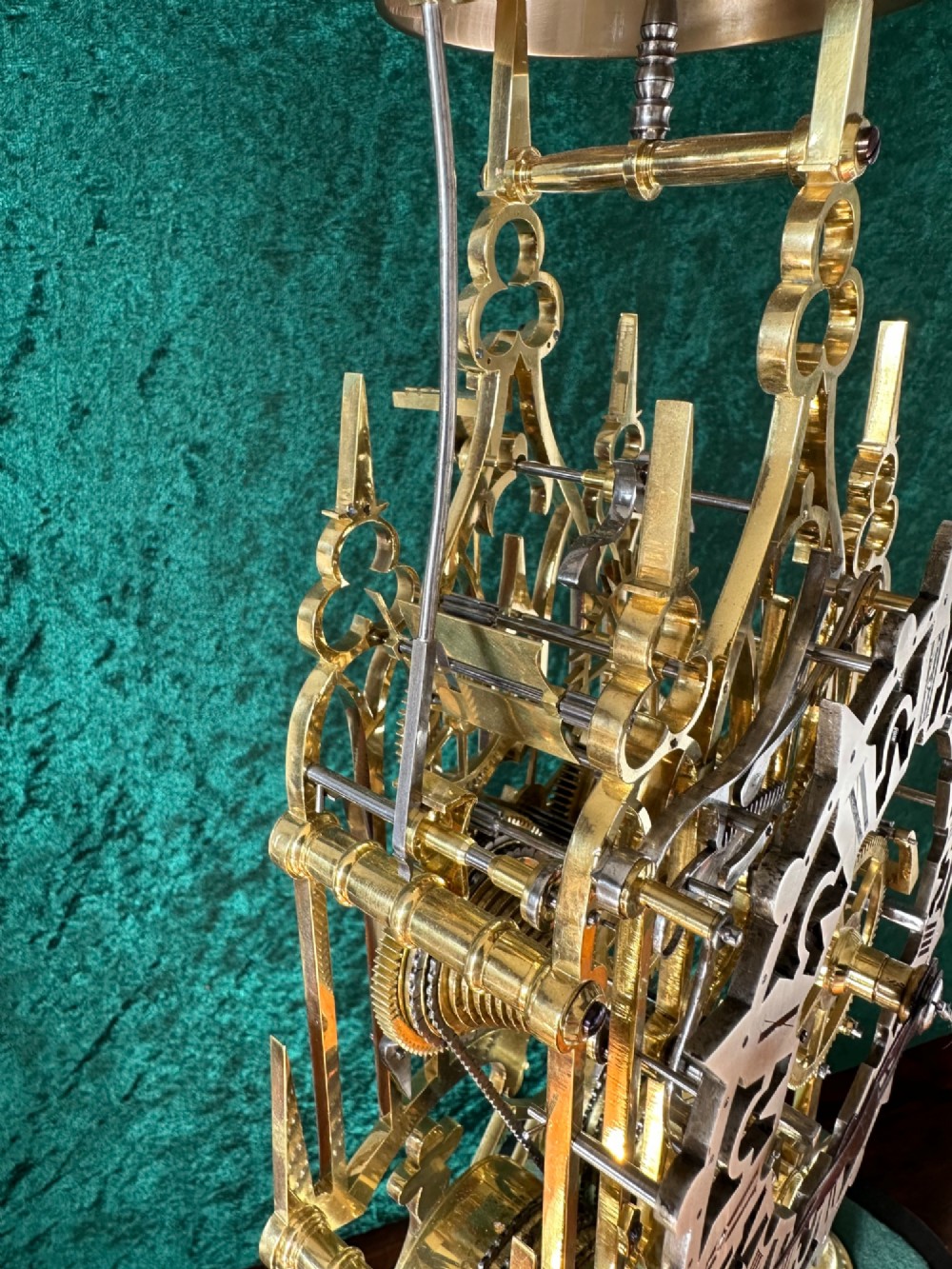 A Victorian brass double fusee skeleton clock displaying exposed internal gearing, a gothic pierced frame, a silvered chapter ring, and a top-mounted bell. View VII