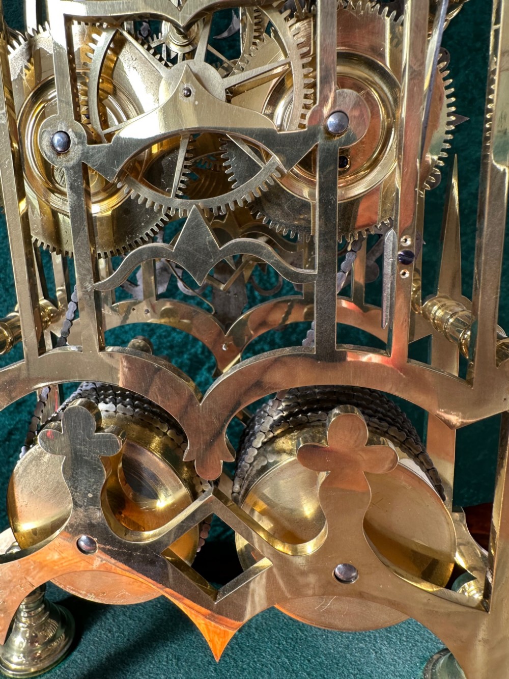 A Victorian brass double fusee skeleton clock displaying exposed internal gearing, a gothic pierced frame, a silvered chapter ring, and a top-mounted bell. View IX