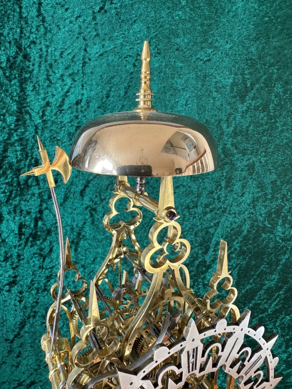 A Victorian brass double fusee skeleton clock displaying exposed internal gearing, a gothic pierced frame, a silvered chapter ring, and a top-mounted bell. View X