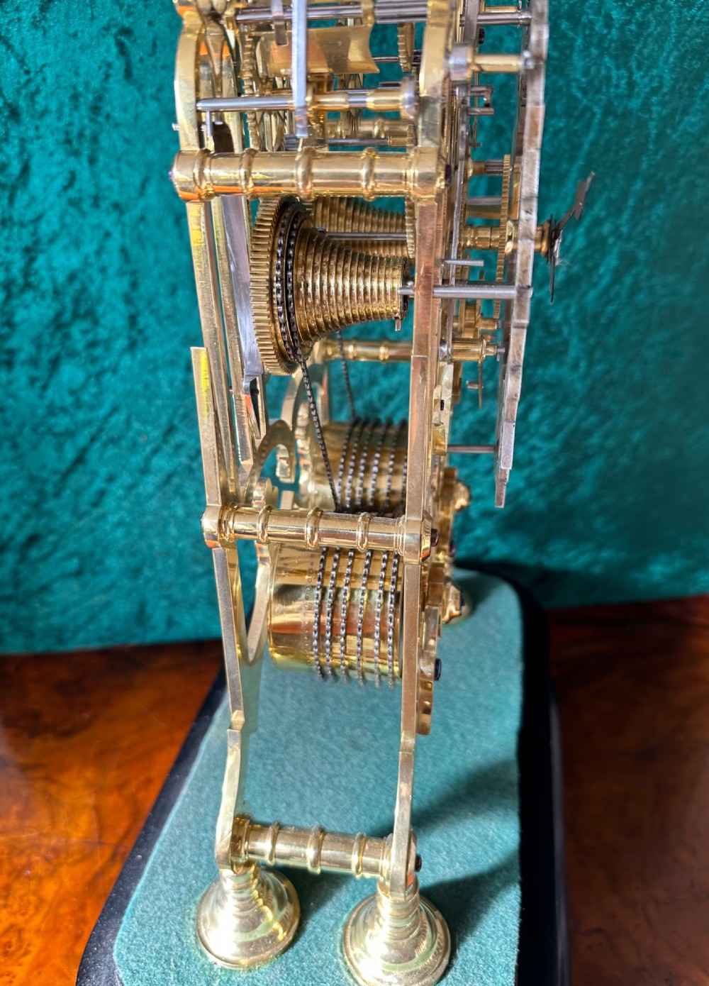 A Victorian brass double fusee skeleton clock displaying exposed internal gearing, a gothic pierced frame, a silvered chapter ring, and a top-mounted bell. View XII