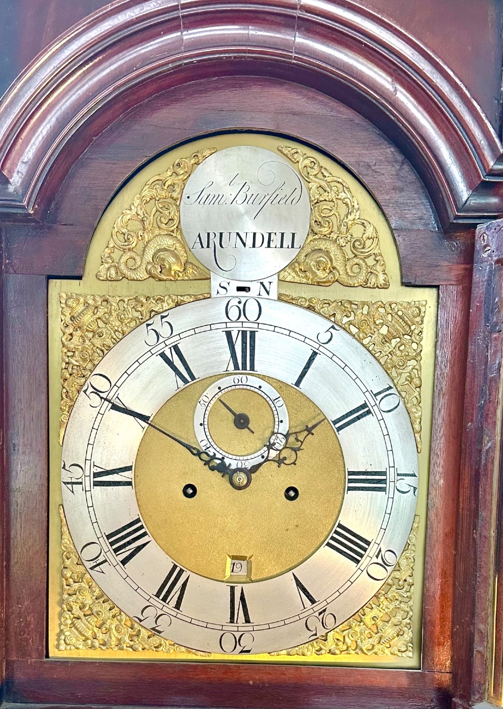 A tall Georgian mahogany longcase clock featuring brass eagle finials, a swan-neck pediment, fluted columns, and an engraved brass dial. View II