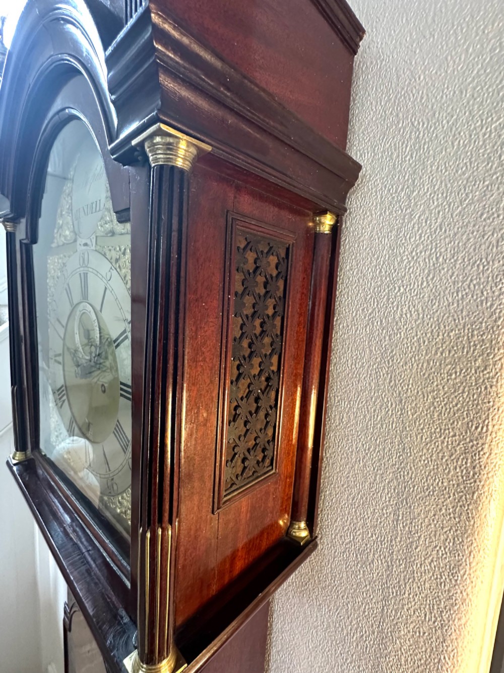A tall Georgian mahogany longcase clock featuring brass eagle finials, a swan-neck pediment, fluted columns, and an engraved brass dial. View VI