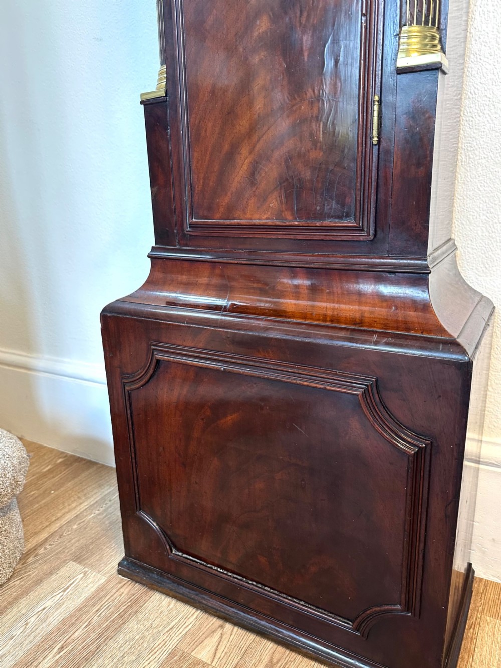 A tall Georgian mahogany longcase clock featuring brass eagle finials, a swan-neck pediment, fluted columns, and an engraved brass dial. View VII
