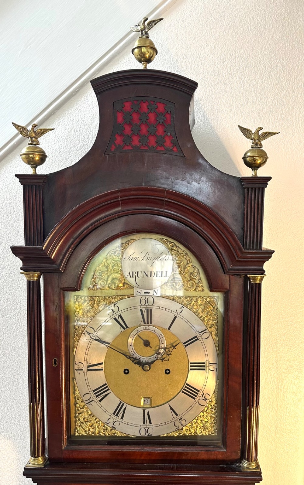 A tall Georgian mahogany longcase clock featuring brass eagle finials, a swan-neck pediment, fluted columns, and an engraved brass dial. View VIII