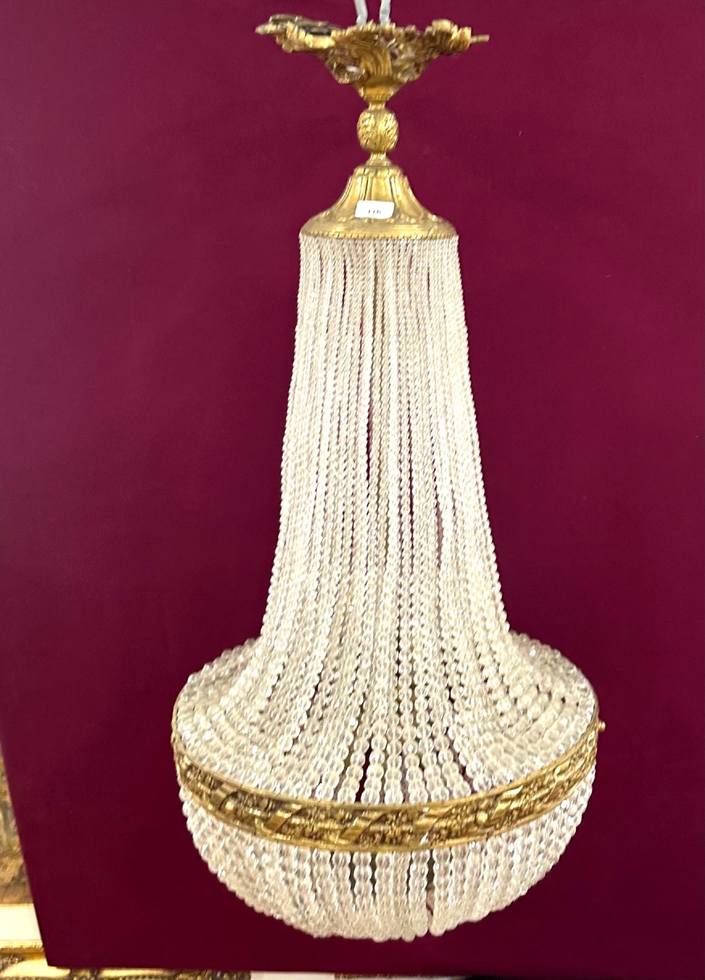 A French Empire style crystal basket chandelier featuring cascading glass bead strands and a chased gilt-bronze ornamental ring. View II
