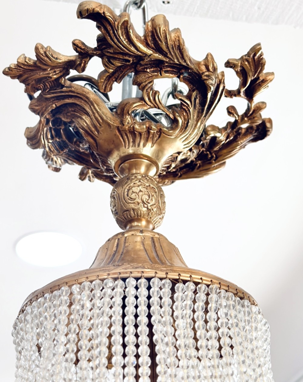 A French Empire style crystal basket chandelier featuring cascading glass bead strands and a chased gilt-bronze ornamental ring. View VI