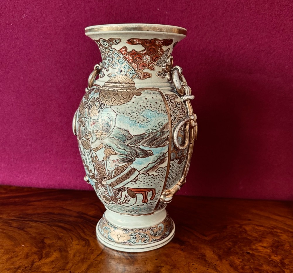 A Japanese Satsuma earthenware vase with crackle glaze, detailed polychrome figures, and heavy gold enamelling.