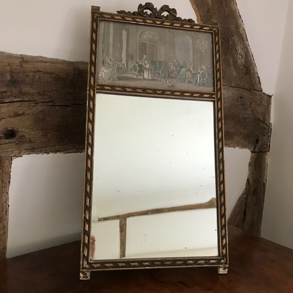 A rectangular French gilded easel mirror featuring a carved twist border, a top panel depicting a period scene, and mirror glass below.