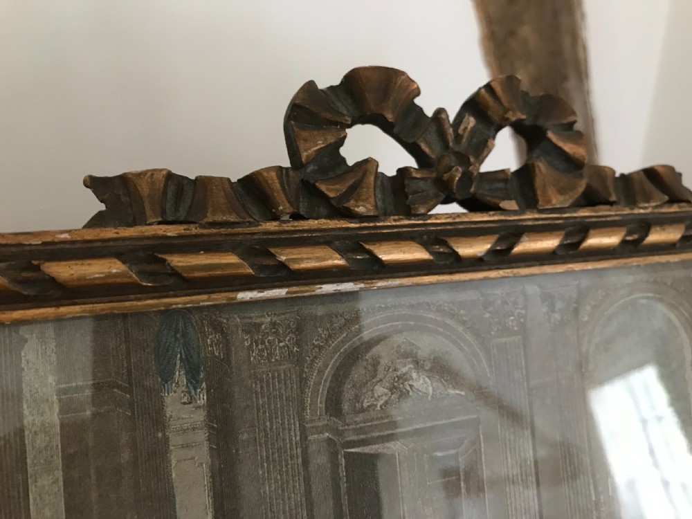 A rectangular French gilded easel mirror featuring a carved twist border, a top panel depicting a period scene, and mirror glass below. View III