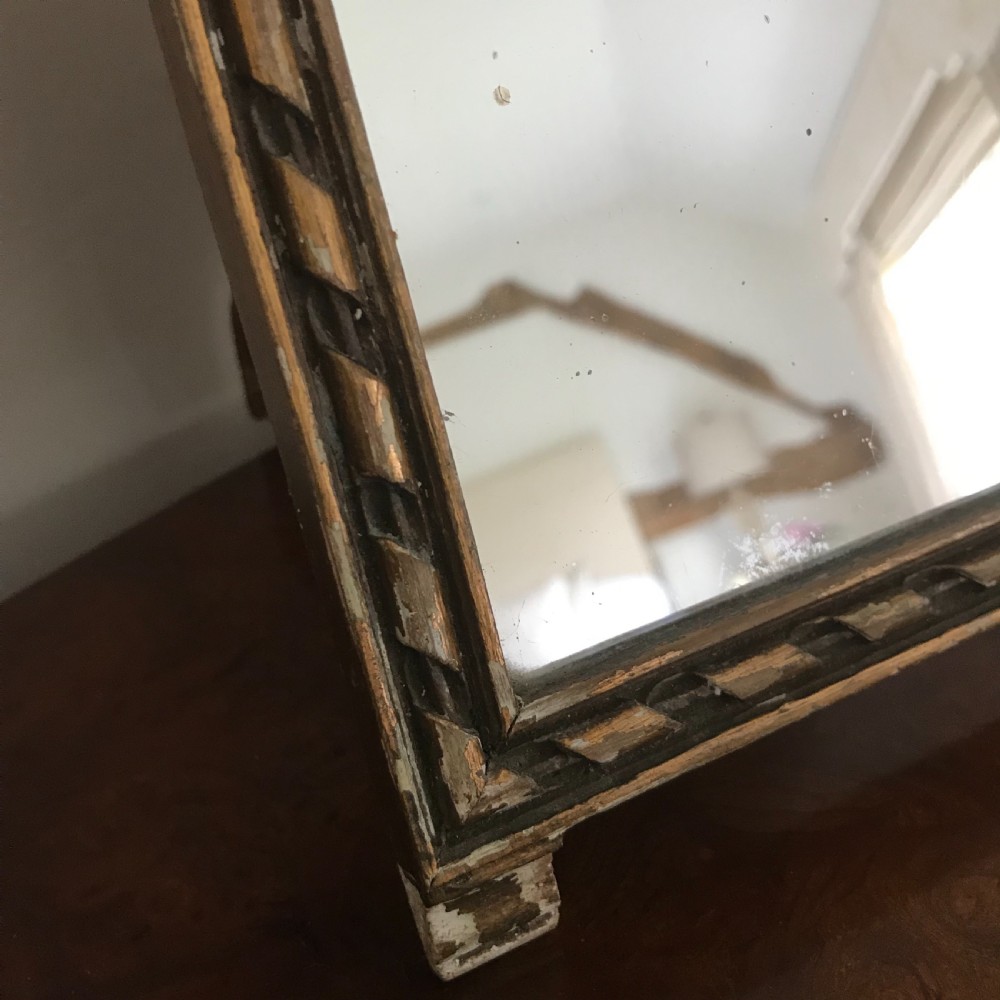 A rectangular French gilded easel mirror featuring a carved twist border, a top panel depicting a period scene, and mirror glass below. View IV