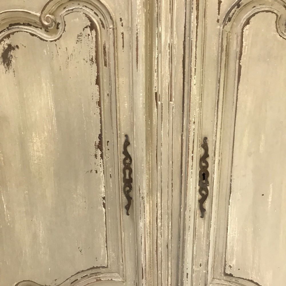 A pair of grey painted wooden doors featuring carved Louis XV style moulded panels and a distressed paint finish with central iron escutcheons. View II