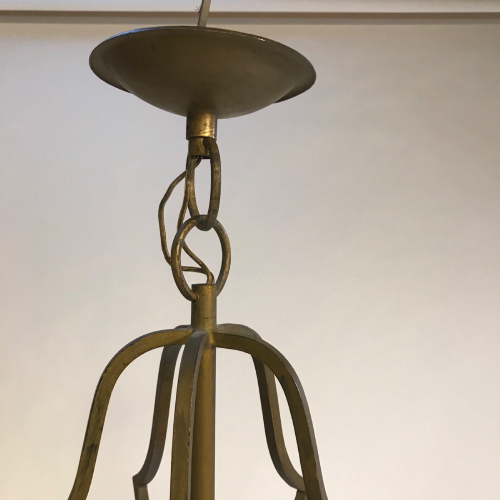 A large French brass hall lantern with clear glass side panels, a scrolled metal crown, finials, and a four-light central fitting. View V