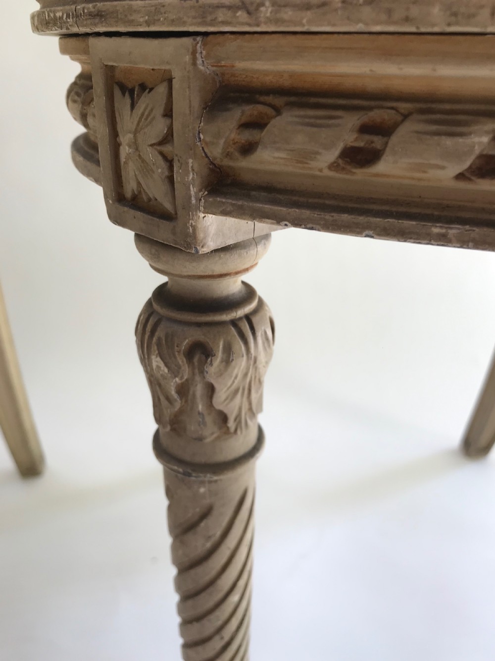 A pair of French painted timber side chairs featuring foliate back carving, woven cane seats, and spiral-turned front legs. View VII