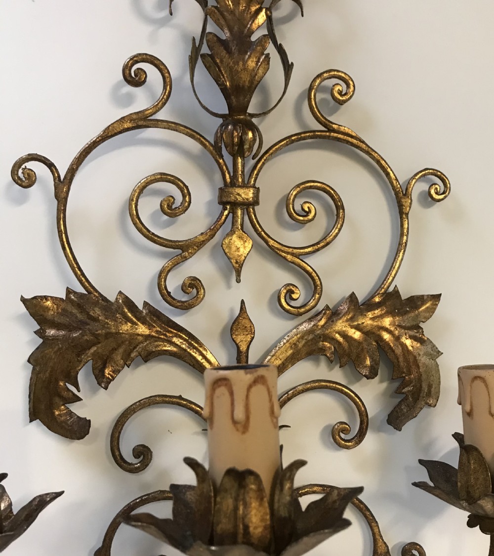 A pair of large French gilt metal three-light wall sconces with elaborate scrollwork and acanthus leaf details. View III