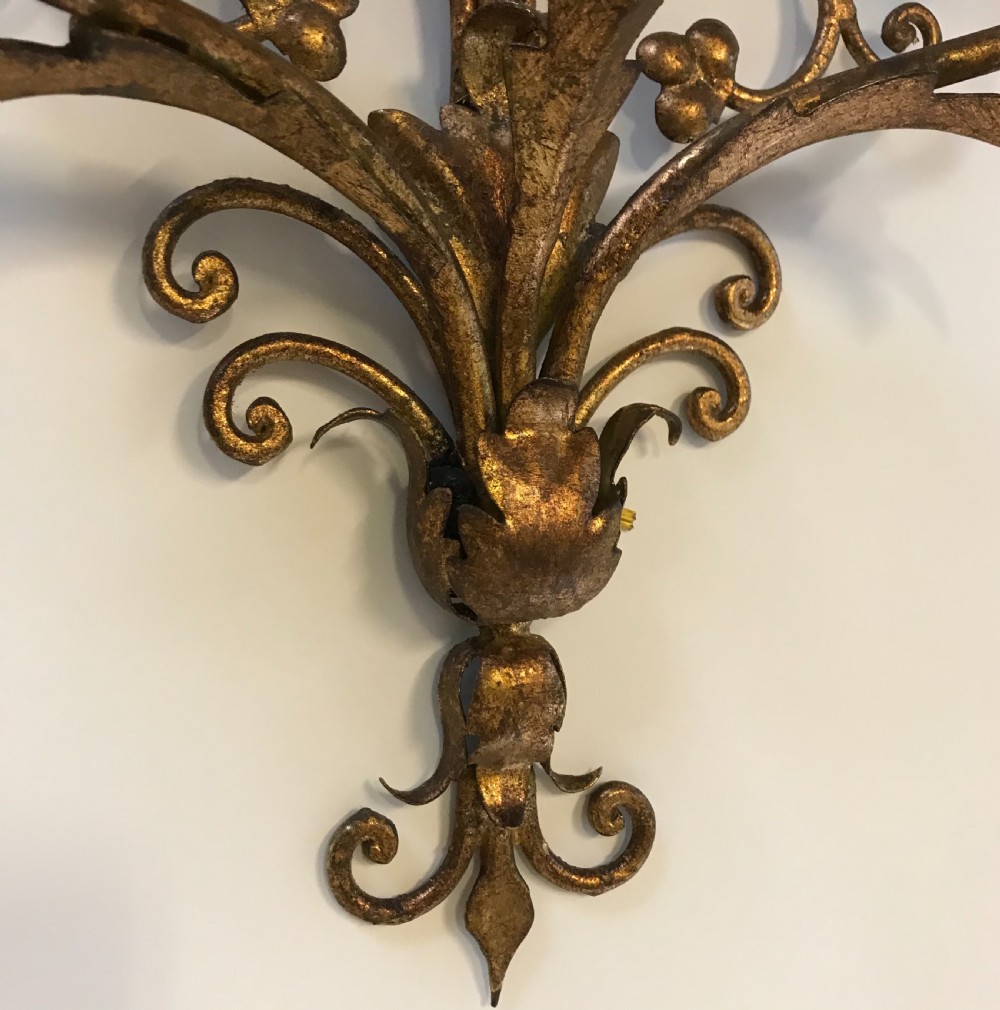 A pair of large French gilt metal three-light wall sconces with elaborate scrollwork and acanthus leaf details. View V