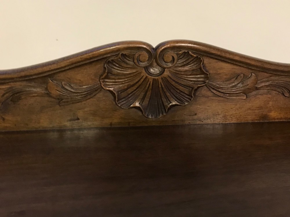 A hand-carved French walnut open bookcase featuring three shelves, carved floral cresting, panelled sides, and cabriole legs. View III