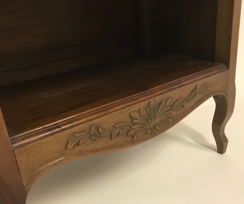 A hand-carved French walnut open bookcase featuring three shelves, carved floral cresting, panelled sides, and cabriole legs. View IV