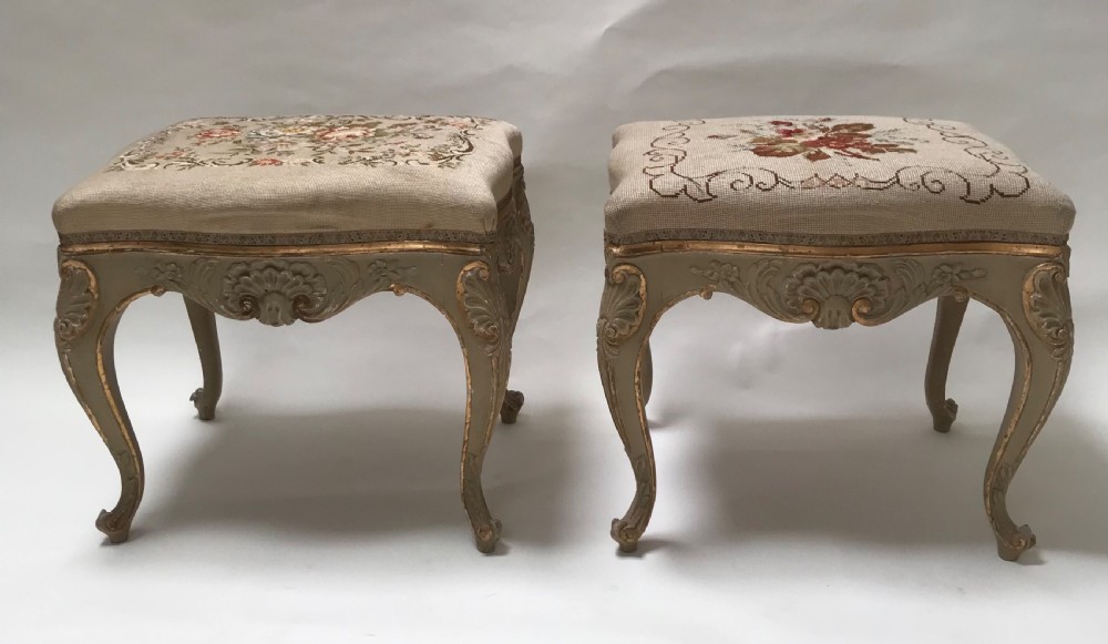 A pair of French Louis XV style footstools with painted cabriole legs, gilded accents, and floral needlepoint upholstery. View VI