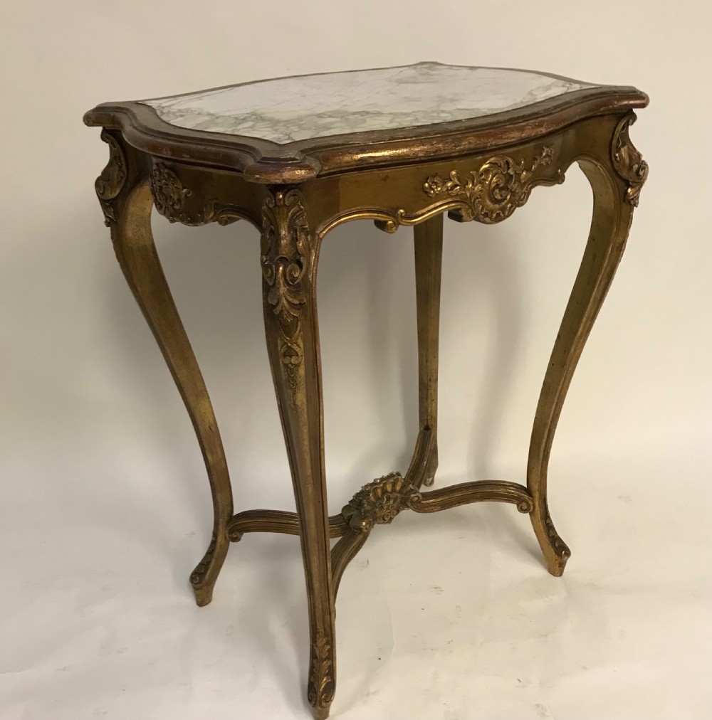 A French Louis XV style giltwood side table featuring a contoured white marble top, carved cabriole legs, and an X-shaped stretcher with a central shell motif. View III