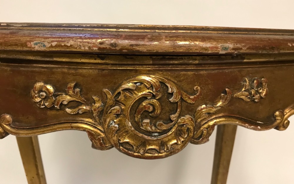A French Louis XV style giltwood side table featuring a contoured white marble top, carved cabriole legs, and an X-shaped stretcher with a central shell motif. View IV
